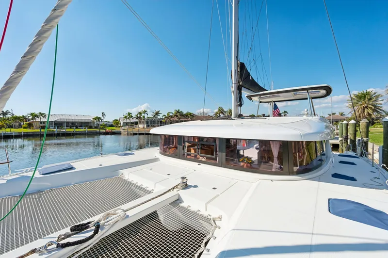 Slide: The Image of 2019 Lagoon 42 catamaran docked in sunny marina, showcasing spacious deck and sleek design. - 22