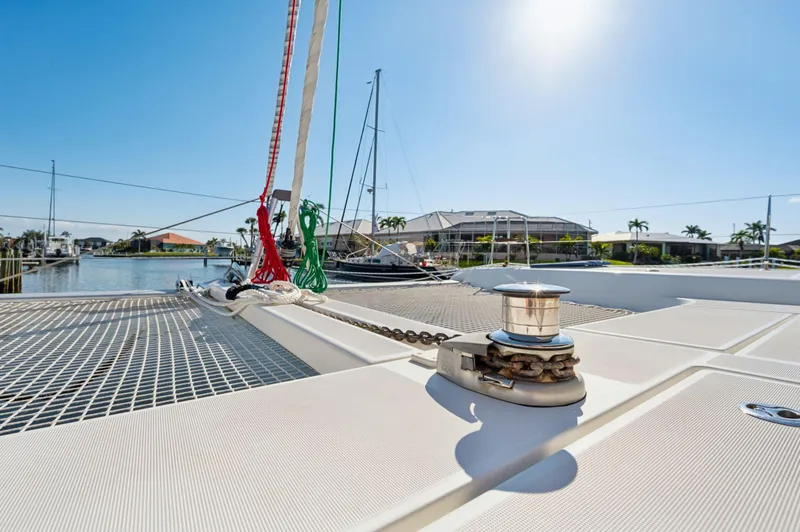 Slide: The Image of 2019 Lagoon 42 catamaran deck with winch, docked in sunny marina. - 24