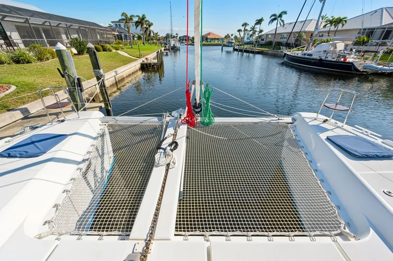 Slide: The Image of 2019 Lagoon 42 catamaran docked in a scenic canal with palm trees. - 25
