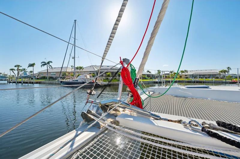 Slide: The Image of Lagoon 42 catamaran, 2019 model, docked in a sunny marina with palm trees. - 27