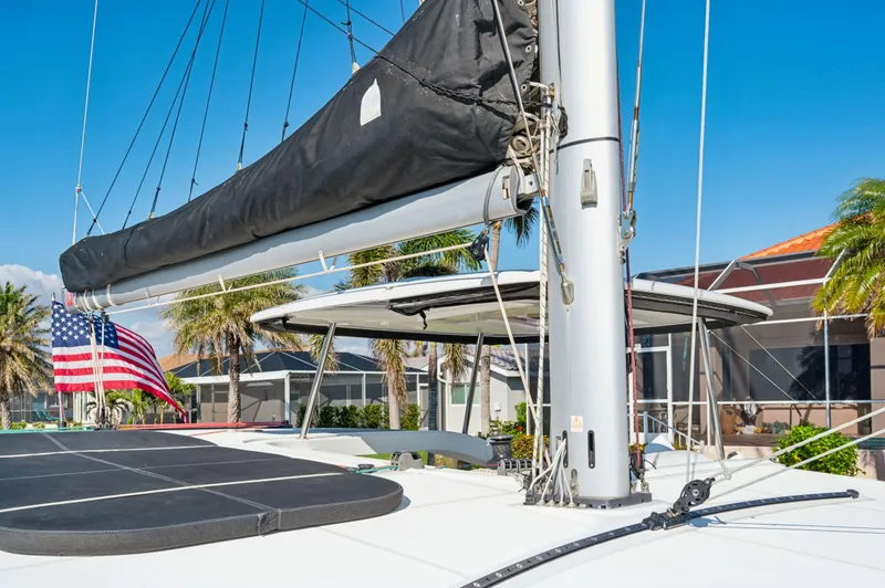 Slide: The Image of 2019 Lagoon 42 catamaran with American flag, docked near palm trees and buildings. - 30
