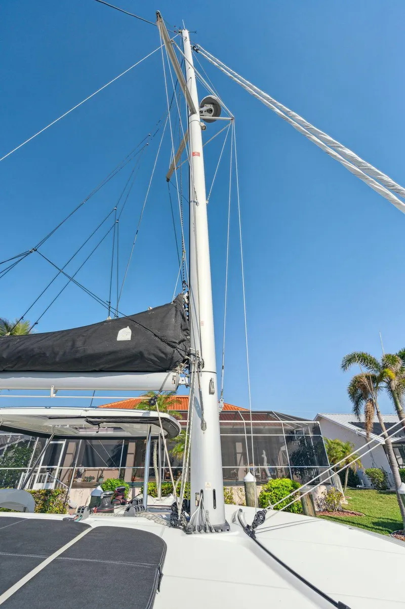 Slide: The Image of 2019 Lagoon 42 sailboat mast against clear blue sky, with tropical background. - 31