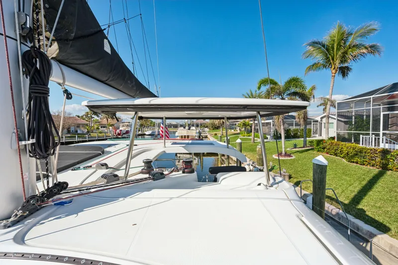 Slide: The Image of 2019 Lagoon 42 catamaran docked, featuring spacious deck and tropical surroundings. - 35