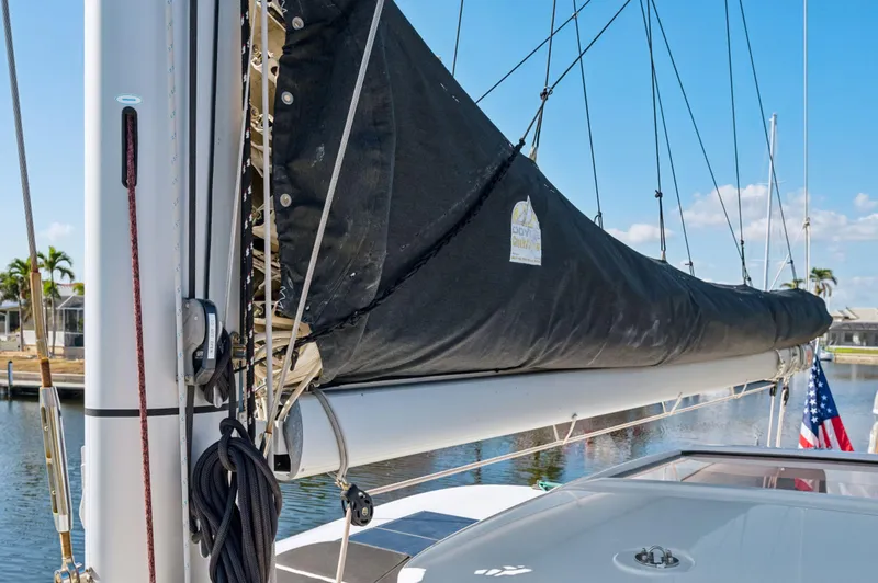 Slide: The Image of Lagoon 42 sailboat mast and boom, 2019 model, docked with American flag visible. - 36