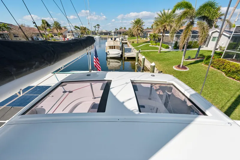Slide: The Image of 2019 Lagoon 42 catamaran docked in a sunny marina with palm trees. - 37