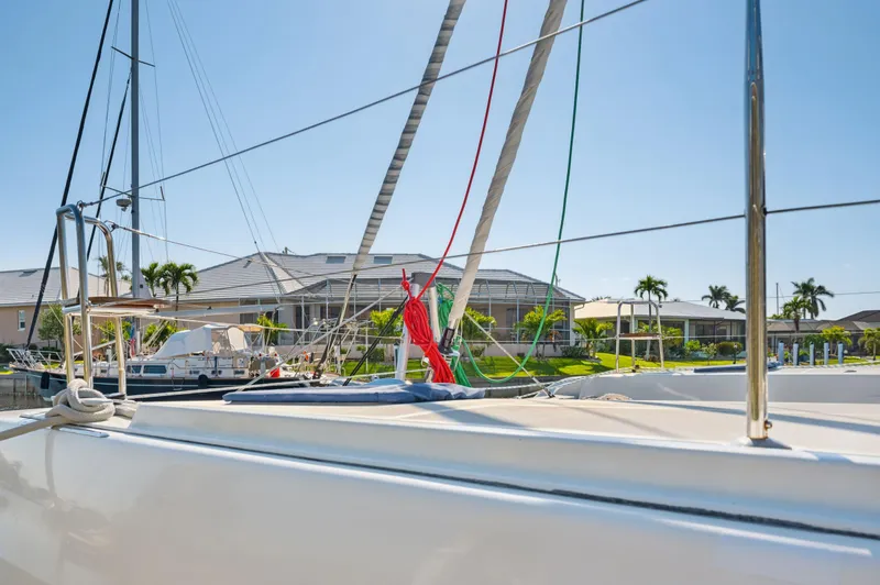 Slide: The Image of 2019 Lagoon 42 catamaran docked in a sunny marina with palm trees. - 38