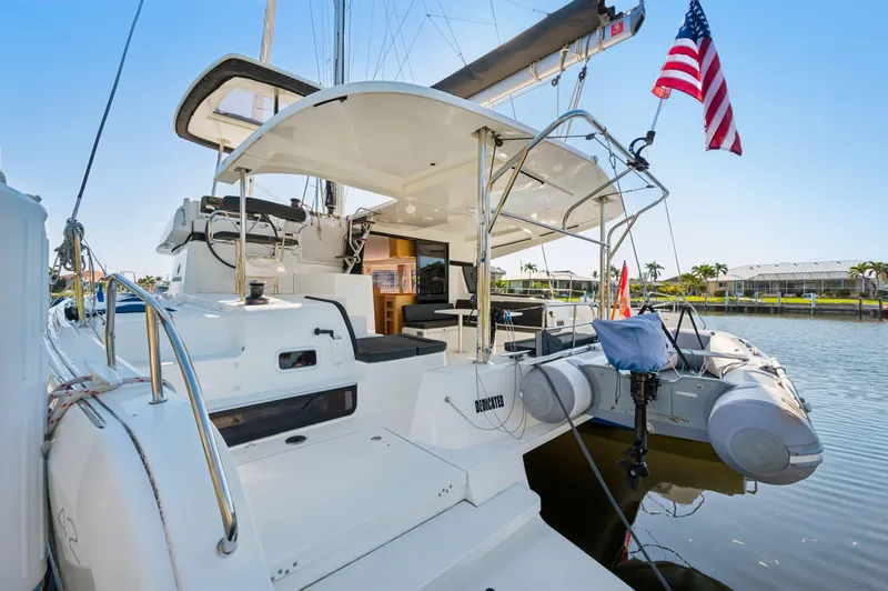 Slide: The Image of 2019 Lagoon 42 catamaran docked, featuring spacious deck and American flag. - 40