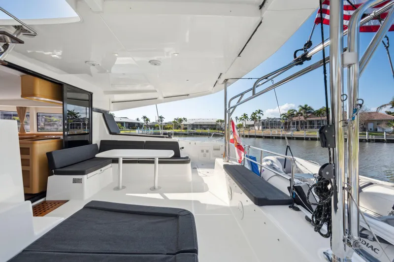 Slide: The Image of 2019 Lagoon 42 catamaran with spacious deck, seating, and waterfront view. - 41