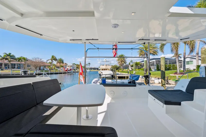 Slide: The Image of 2019 Lagoon 42 yacht interior with seating, table, and waterfront view. - 43