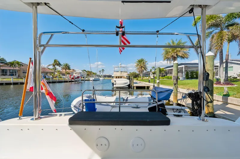 Slide: The Image of 2019 Lagoon 42 catamaran docked in a sunny marina with palm trees. - 45