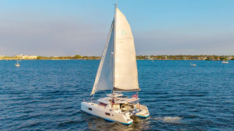 Slide: The Image of 2019 Lagoon 42 catamaran sailing on a calm blue sea under clear skies. - 5