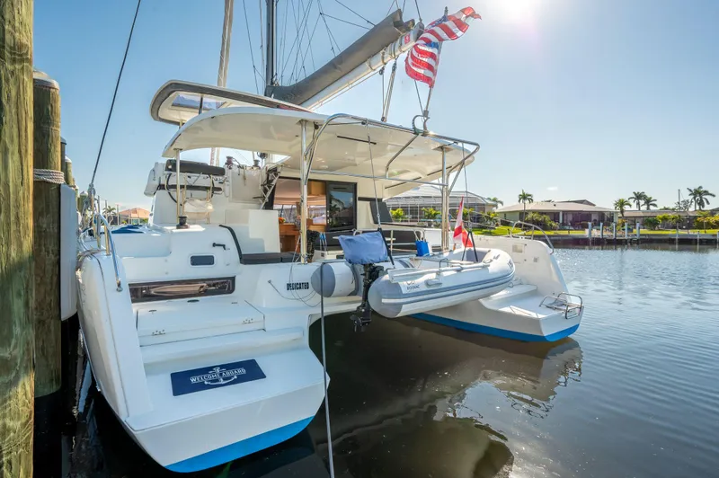 Slide: The Image of 2019 Lagoon 42 catamaran docked, featuring a spacious deck and American flag. - 7