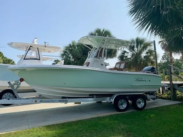 The Image of 2025 Pioneer 222 Islander boat on trailer, surrounded by palm trees. - 0