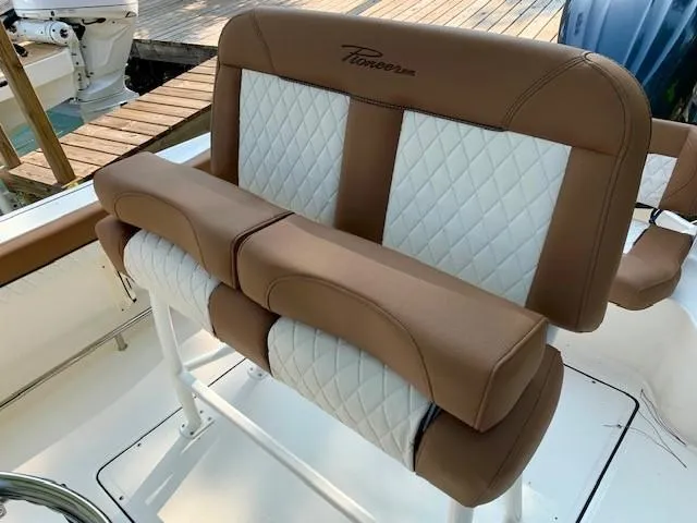 Slide: The Image of 2025 Pioneer 222 Islander boat seating with brown and white quilted upholstery. - 10