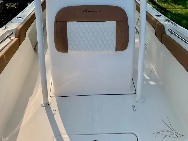 Slide: The Image of 2025 Pioneer 222 Islander boat interior with tan and white seating. - 12