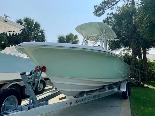 Slide: The Image of 2025 Pioneer 222 Islander boat on trailer, surrounded by palm trees. - 4