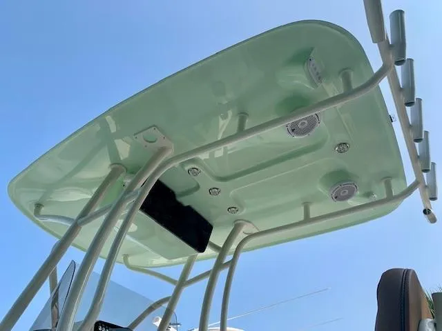 Slide: The Image of T-top of 2025 Pioneer 222 Islander boat with speakers and rod holders against blue sky. - 6