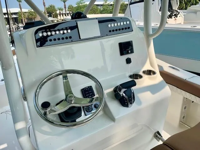 Slide: The Image of 2025 Pioneer 222 Islander boat console with steering wheel, controls, and cup holders. - 7