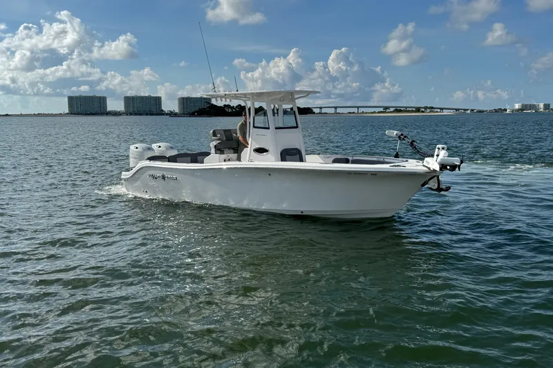 Slide: The Image of 2025 NauticStar 252 Legacy boat cruising on open water under a partly cloudy sky. - 11