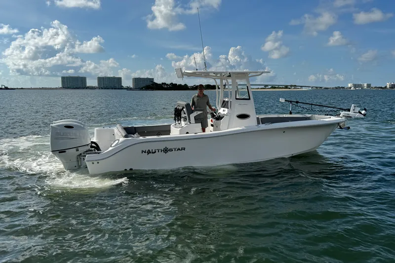 Slide: The Image of 2025 NauticStar 252 Legacy boat cruising on open water under a clear blue sky. - 15