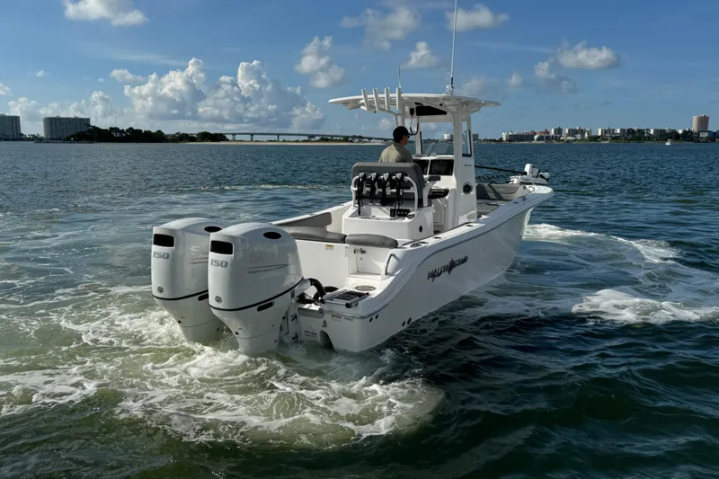 Slide: The Image of 2025 NauticStar 252 Legacy boat cruising on open water with twin engines. - 16