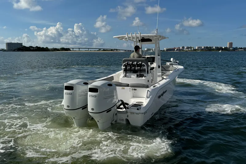 Slide: The Image of 2025 NauticStar 252 Legacy boat cruising on open water with twin engines. - 17