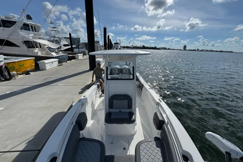 Slide: The Image of 2025 NauticStar 252 Legacy boat docked at marina under blue sky. - 25