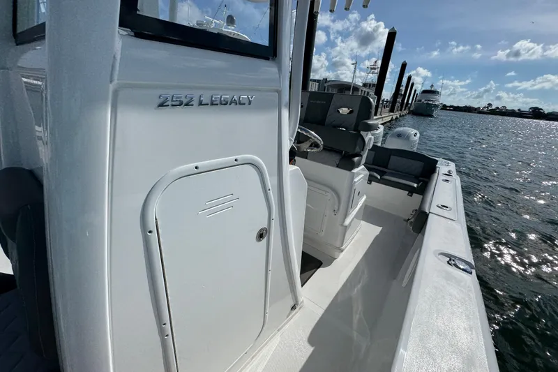 Slide: The Image of 2025 NauticStar 252 Legacy boat docked, showcasing sleek design and spacious seating. - 27