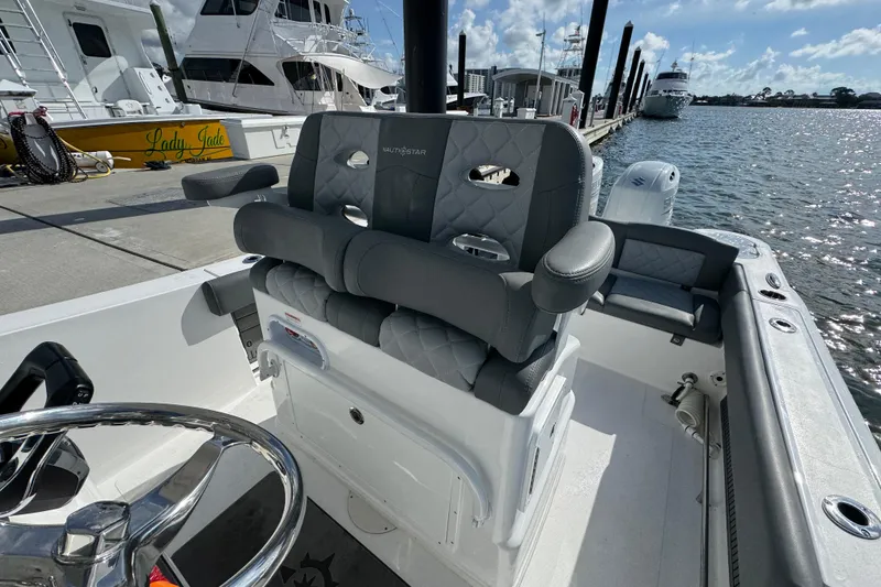 Slide: The Image of 2025 NauticStar 252 Legacy boat interior with plush seating at marina. - 29