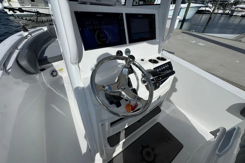 Slide: The Image of 2025 NauticStar 252 Legacy boat helm with modern controls and steering wheel. - 31