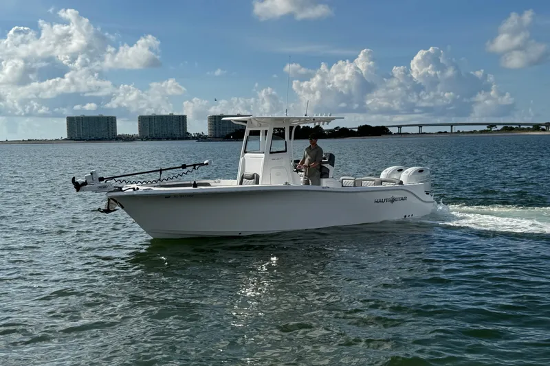 Slide: The Image of 2025 NauticStar 252 Legacy boat cruising on open water under a cloudy sky. - 4