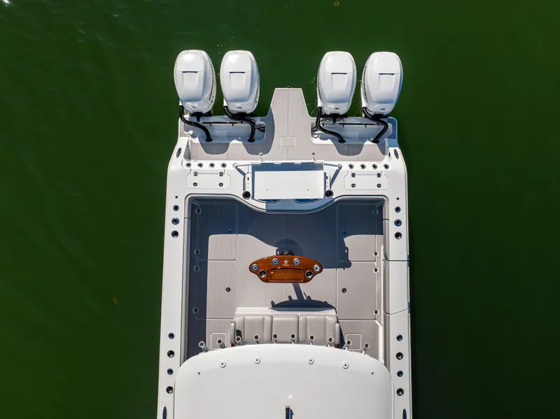 Slide: The Image of Aerial view of 2022 Freeman 43 boat with four engines on green water. - 10
