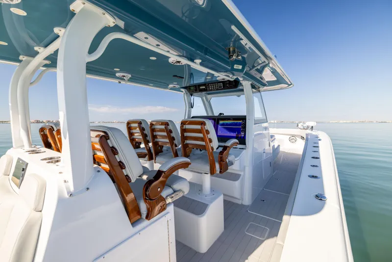 Slide: The Image of 2022 Freeman 43 boat interior with wooden seats and modern dashboard on calm water. - 32