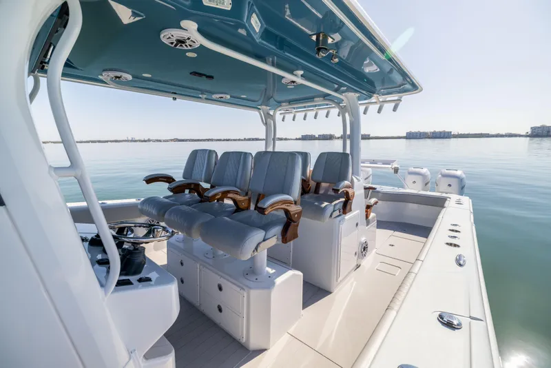 Slide: The Image of 2022 Freeman 43 boat interior with cushioned seating and steering console on calm water. - 34