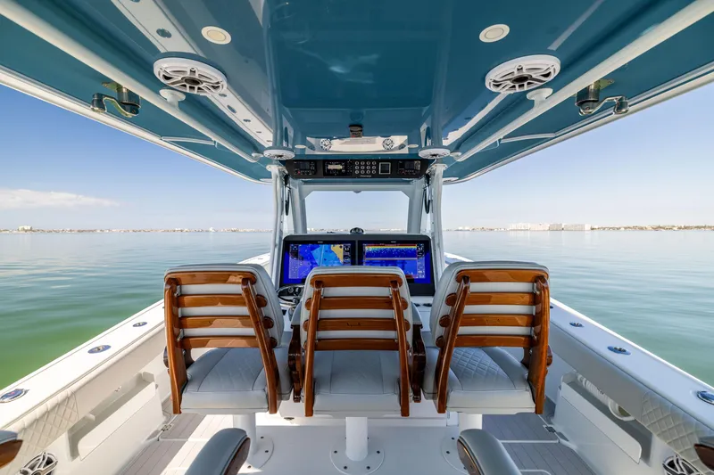 Slide: The Image of 2022 Freeman 43 boat interior with navigation screens and wooden chairs on calm water. - 38