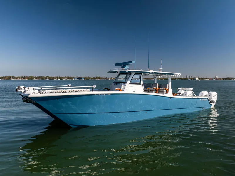 Slide: The Image of 2022 Freeman 43 boat on calm water, featuring a sleek blue design. - 4