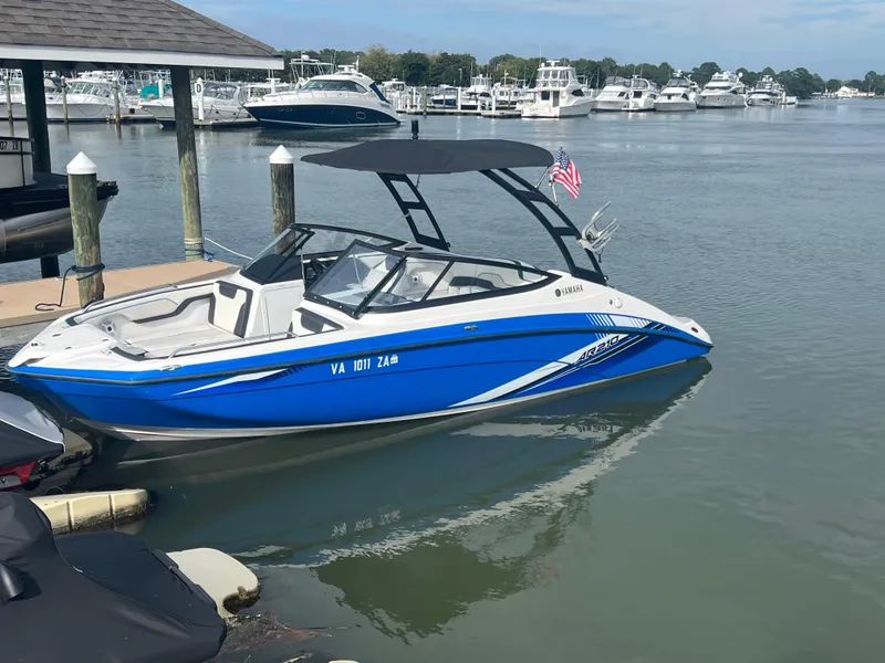 Slide: The Image of 2019 Yamaha AR210 boat docked in a marina, featuring a sleek blue and white design. - 2