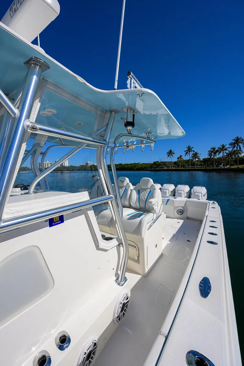 Slide: The Image of 2008 SeaVee 39b boat with sleek design, blue sky, and palm trees in the background. - 17