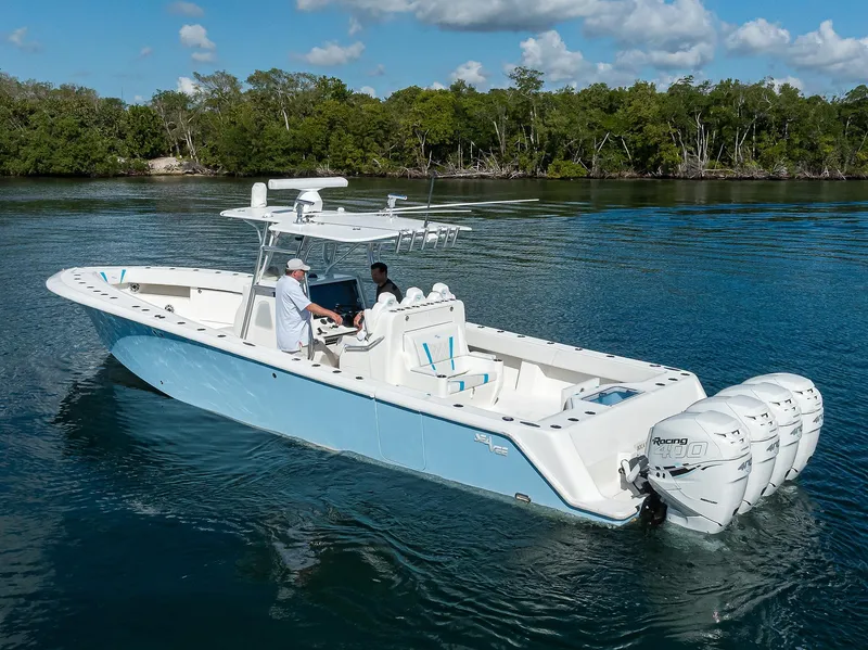 Slide: The Image of 2008 SeaVee 39b boat on calm water, featuring triple outboard engines, with lush greenery in the background. - 32