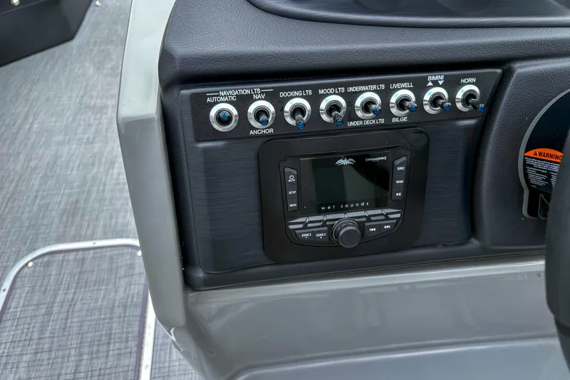 Slide: The Image of Control panel of 2025 Trifecta 24 RF CS boat with switches and audio system. - 11