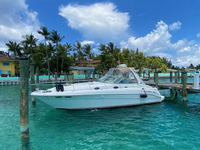 The Image of 2002 Sea Ray Sundancer yacht docked in tropical marina with clear blue water. - 1