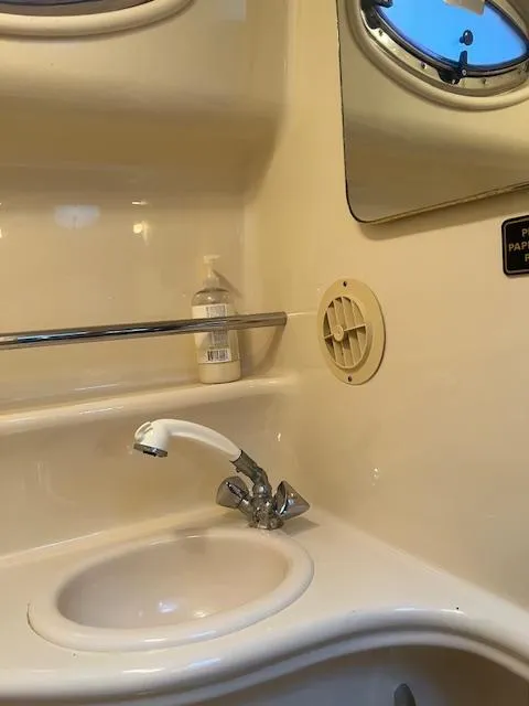 Slide: The Image of 2002 Sea Ray Sundancer bathroom sink with faucet and mirror. - 13