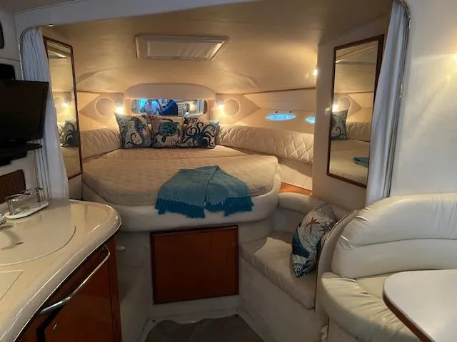 Slide: The Image of Interior of 2002 Sea Ray Sundancer yacht with cozy bed, mirrors, and elegant decor. - 14