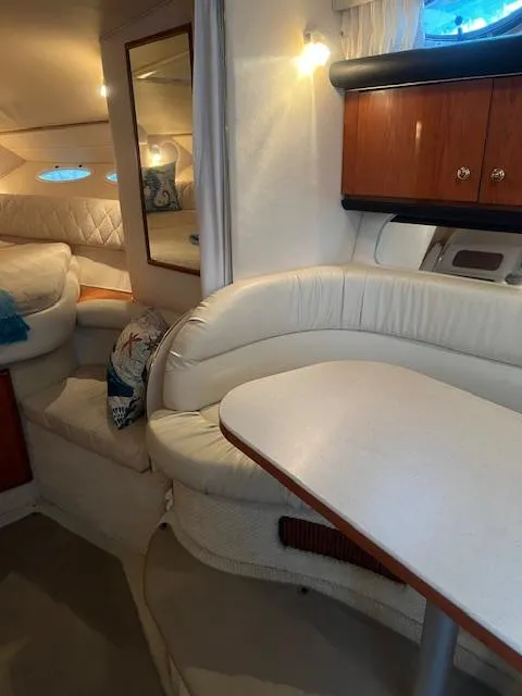 Slide: The Image of Interior of a 2002 Sea Ray Sundancer yacht with white seating and wooden cabinets. - 17