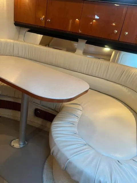 Slide: The Image of 2002 Sea Ray Sundancer interior with cream leather seating and wooden cabinets. - 18