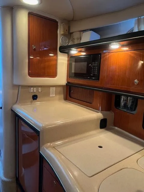 Slide: The Image of 2002 Sea Ray Sundancer yacht interior kitchen with wood cabinets and modern appliances. - 20