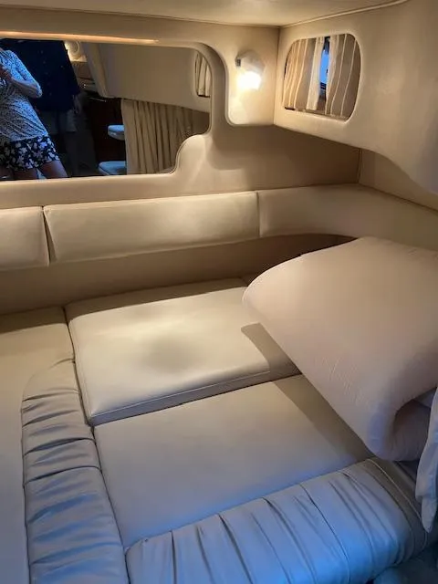 Slide: The Image of 2002 Sea Ray Sundancer cabin interior with beige upholstery and cozy lighting. - 23