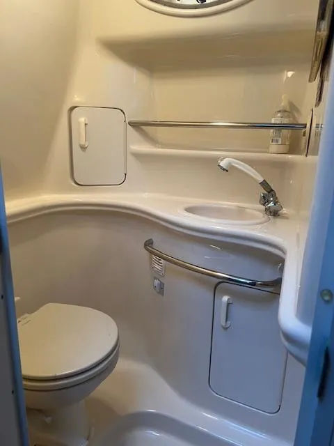Slide: The Image of 2002 Sea Ray Sundancer bathroom with toilet, sink, and storage shelves. - 4