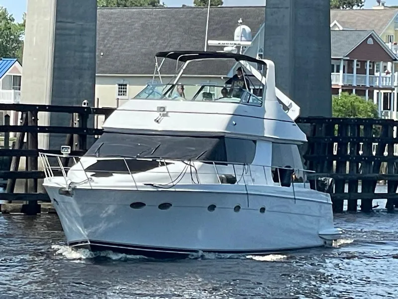 The Image of 1998 Carver 530 Voyager Pilothouse yacht navigating through a waterway. - 0