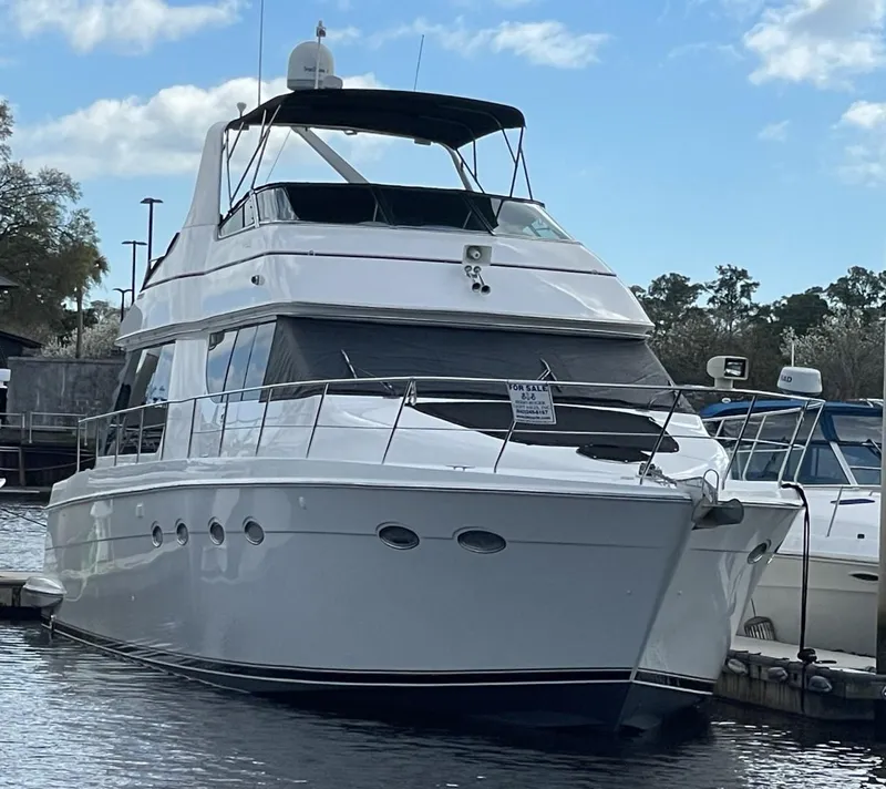Slide: The Image of 1998 Carver 530 Voyager Pilothouse yacht docked at marina under blue sky. - 13